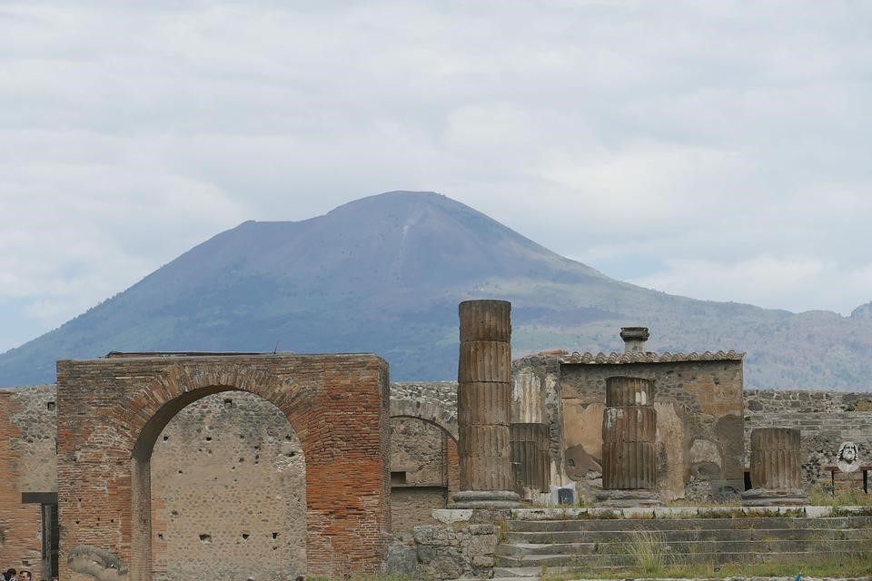 Freigelegte Stadtteile von Pompeji heute. Der Vesuv ist im Hintergrund zu sehen.